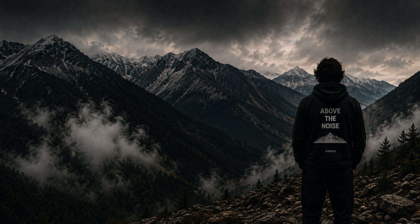 Person standing on a mountain peak with a dramatic sky and clouds